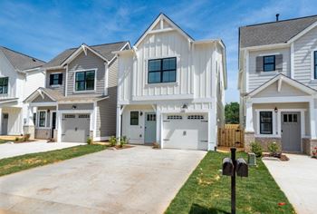 A row of houses with garages and driveways.